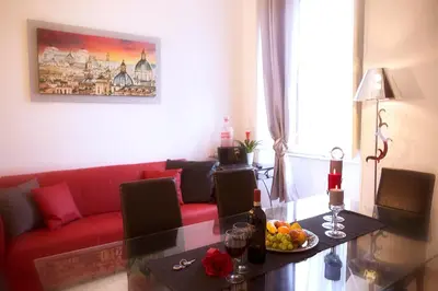 a living room with a red couch and a table at Luxury Domus Amadeus in Rome