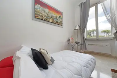 a white bedroom with a white bed and a window at Luxury Domus Amadeus in Rome