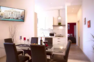 a dining room and kitchen with a glass table and chairs at Luxury Domus Amadeus in Rome