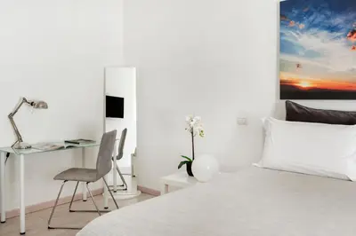 a bedroom with a bed with a desk and a chair at Maison Piazza Cavour in Rome