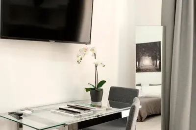 a living room with a glass table and a tv at Maison Piazza Cavour in Rome