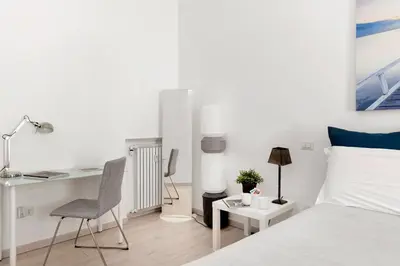 a bedroom with a bed and a desk and a chair at Maison Piazza Cavour in Rome