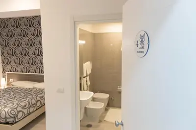 a bathroom with a bed and a toilet and a sink at Metronia Guest House in Rome