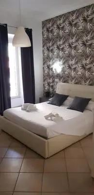 a bedroom with a large white bed with a wall at Campo de Fiori House in Rome