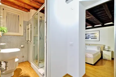 a bathroom with a sink and a bed in a room at Parione Charme - My Extra Home in Rome