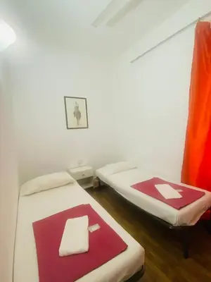 two beds in a room with red and white sheets at Roman Place in Rome