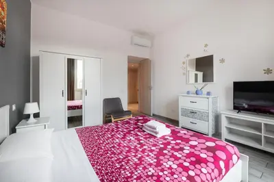 a bedroom with a white bed with a pink blanket at Lilli Home Holidays in Rome