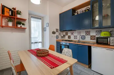 a kitchen with blue cabinets and a wooden table at Lilli Home Holidays in Rome