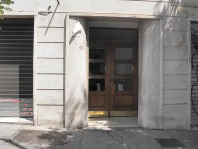 an entrance to a building with a wooden door at Magnifico Cozy Apartment 400m da metroB in Rome