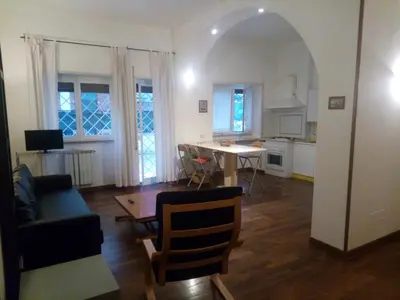 a living room with a table and a kitchen at La Casa di Nonna Betta in Rome