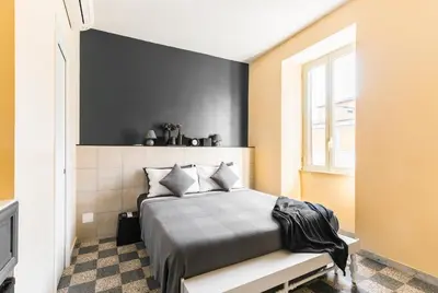 a bedroom with a bed with a black wall at B&B Casa Torpì in Rome