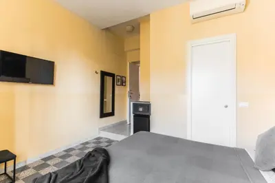a bedroom with a bed and a tv on the wall at B&B Casa Torpì in Rome