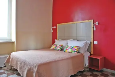 a bedroom with a bed with a red wall at B&B Casa Torpì in Rome