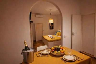 a table with a bottle of wine and a bowl of fruit at CASA VACANZA COLOSSEO WHOLE HOLIDAY HOME APARTMENT da PAMINO & PRISCILLA in Rome
