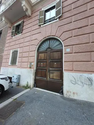 a building with a wooden door on the side of it at CASA VACANZA COLOSSEO WHOLE HOLIDAY HOME APARTMENT da PAMINO & PRISCILLA in Rome