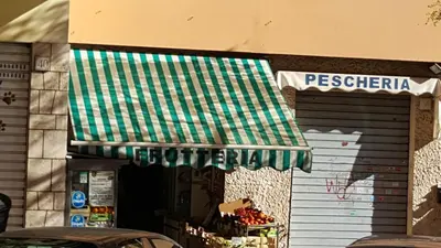 a store with a green and white awning on it at C'è posto per te in Rome