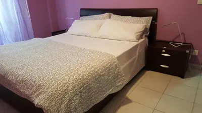 a bed with a white comforter and a night stand at C'è posto per te in Rome