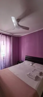 a bedroom with a bed with purple walls and a ceiling at C'è posto per te in Rome