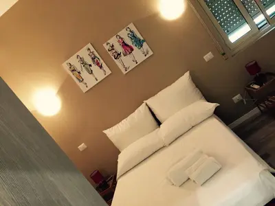 a bedroom with a white bed with two pillows at Affittacamere Roma Tiburtina in Rome