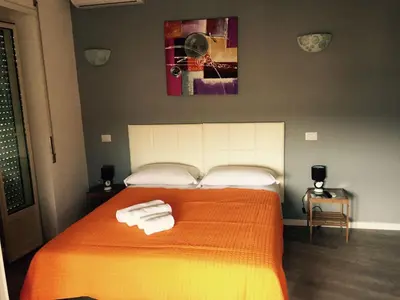 a bedroom with an orange bed with towels on it at Affittacamere Roma Tiburtina in Rome