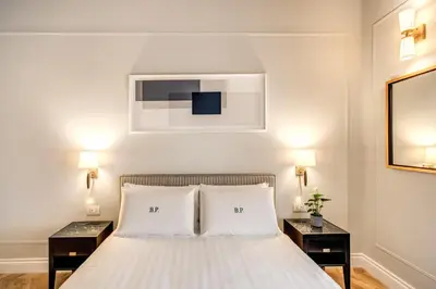 a bedroom with a white bed with two night stands at Babuino Palace&Suites in Rome