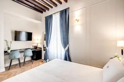 a hotel room with a bed and a desk at Babuino Palace&Suites in Rome