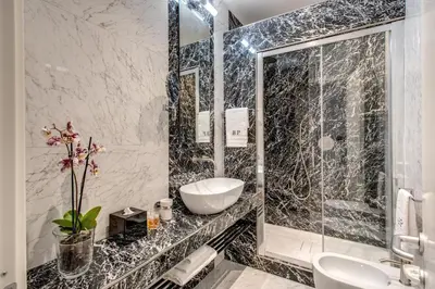 a bathroom with a glass shower and a sink at Babuino Palace&Suites in Rome