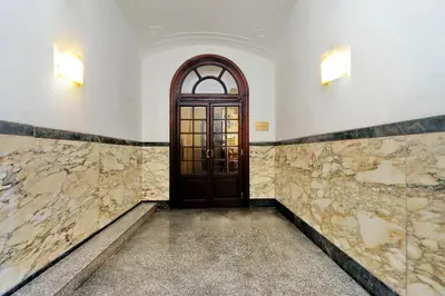 a hallway with a door in a room with marble walls at Vatican Chic B&B in Rome