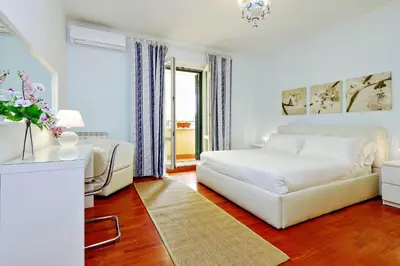 a white bedroom with a bed and a couch at Mecenate Charme Apartment in Rome