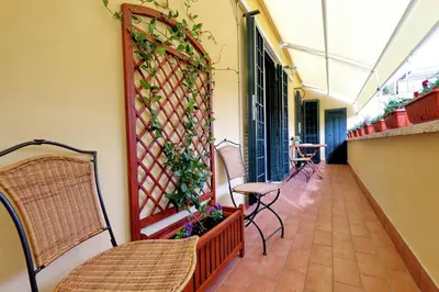 a balcony with chairs and a fence with plants at Mecenate Charme Apartment in Rome