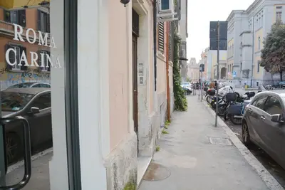 a street with cars parked on the side of a building at Roma Carina in Rome