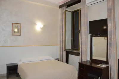 a bedroom with a bed and a mirror and a television at Roma Carina in Rome