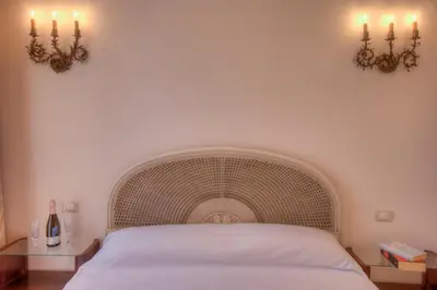 a bedroom with a white bed with two lights on the wall at Rome Charming Suites in Rome
