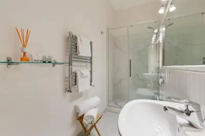 a white bathroom with a sink and a shower at Rome Charming Suites in Rome