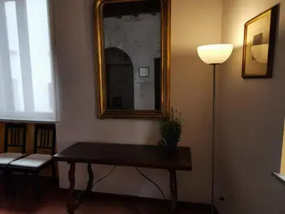 a table in a room with a mirror and a lamp at House Maximo near Vatican in Rome