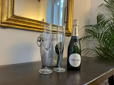 a bottle of champagne and two glasses on a table at House Maximo near Vatican in Rome