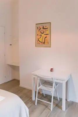 a white table and a chair in a room at Vatican Garden Rooms in Rome