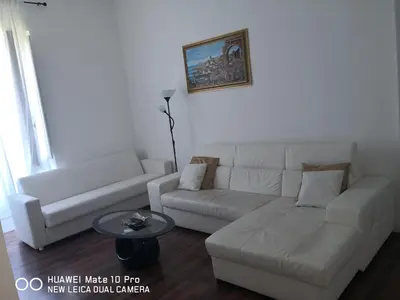 a living room with a white couch and a table at Trastevere four seasons Valadier in Rome