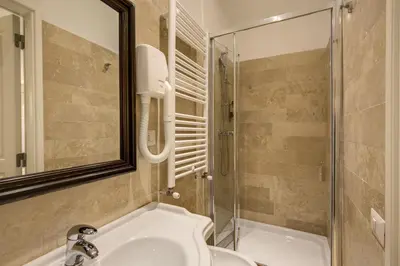 a bedroom with a white bed and a television at Hotel Tito in Rome