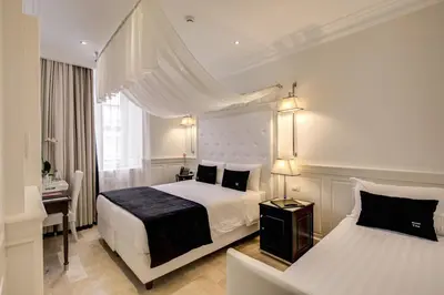 a bedroom with a white bed with a black blanket at Hotel Tito in Rome