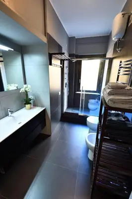 a bathroom with two toilets and a sink and a mirror at The Roman Residence in Rome