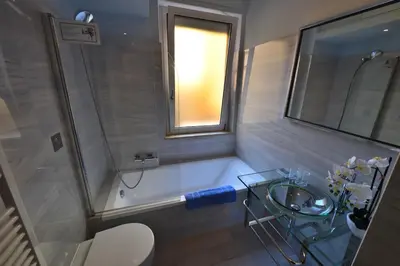 a bathroom with a tub and a sink and a window at The Roman Residence in Rome