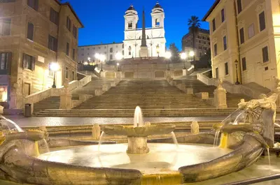 a fountain in front of a building with a clock tower at The Roman Residence in Rome