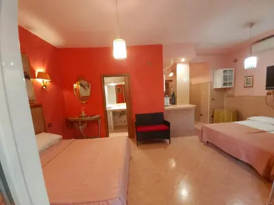 a bedroom with two beds and a red wall at Suites Oliveri Viale Marconi in Rome
