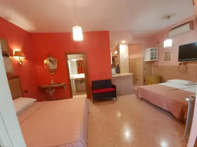 a bedroom with two beds and a red wall at Suites Oliveri Viale Marconi in Rome