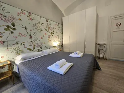 a bedroom with a bed with a dresser and pictures on the wall at Garden House in Rome