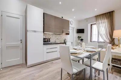 a kitchen with a table and chairs and a refrigerator at AS Vaticano Apartment in Rome