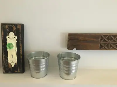 two empty metal cups sitting next to a wooden box at Maru Apartment in Rome