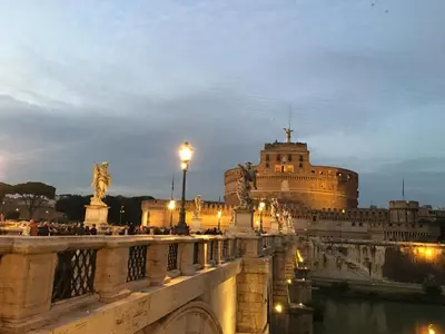 a bridge over a river with a building in the background at Maru Apartment in Rome