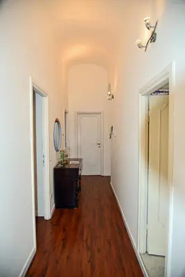 an empty hallway with a wooden floor and white walls at Maru Apartment in Rome